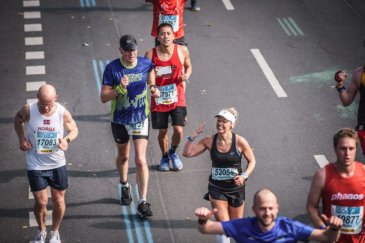 Krystalore Crews smiling and waving mid-marathon