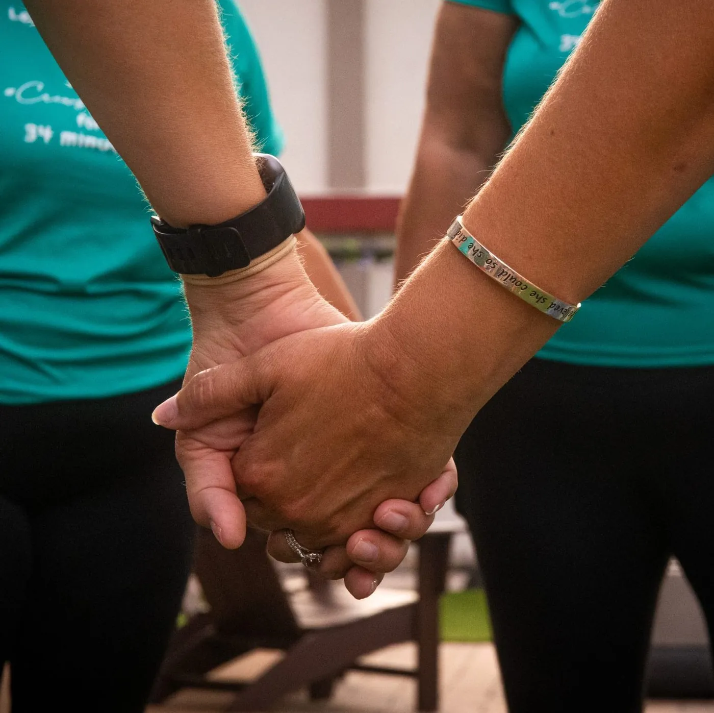 Two people holding hands in support