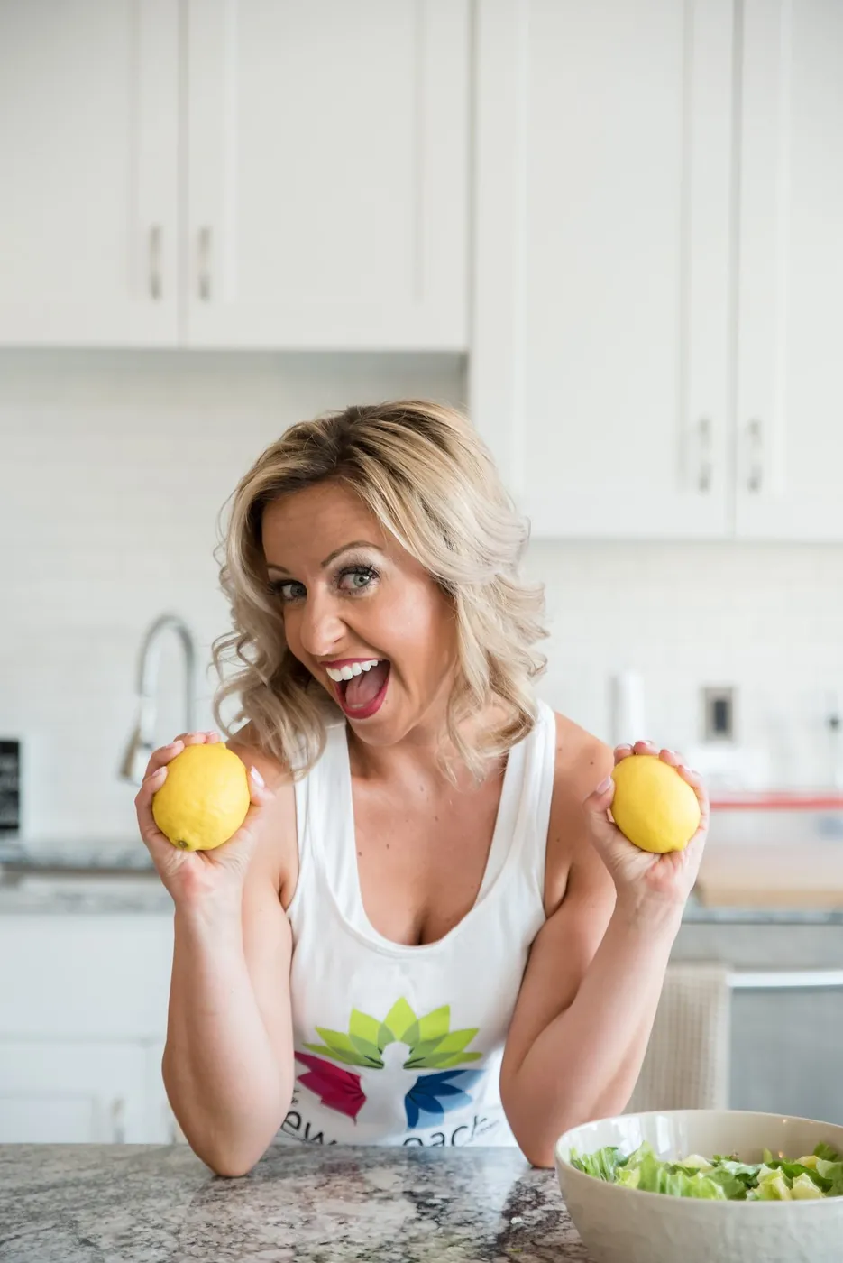 Krystalore Crews in her kitchen holding lemons beside a salad