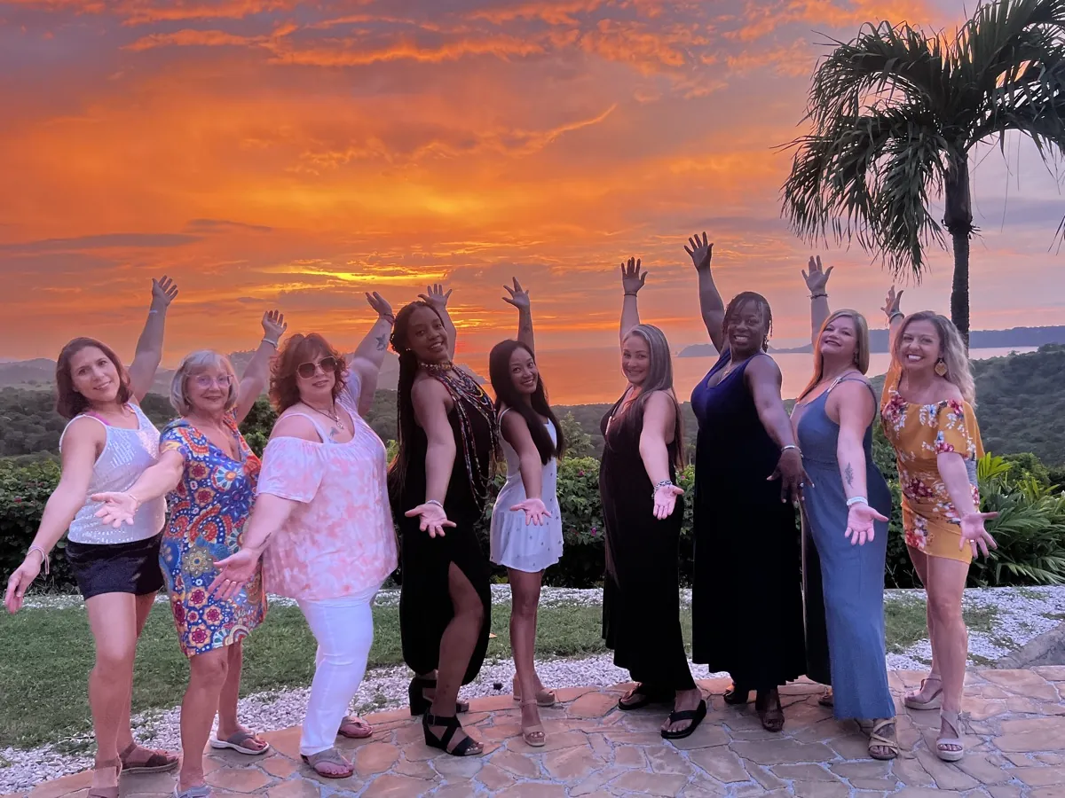 A Revive & Thrive retreat group celebrating at sunset